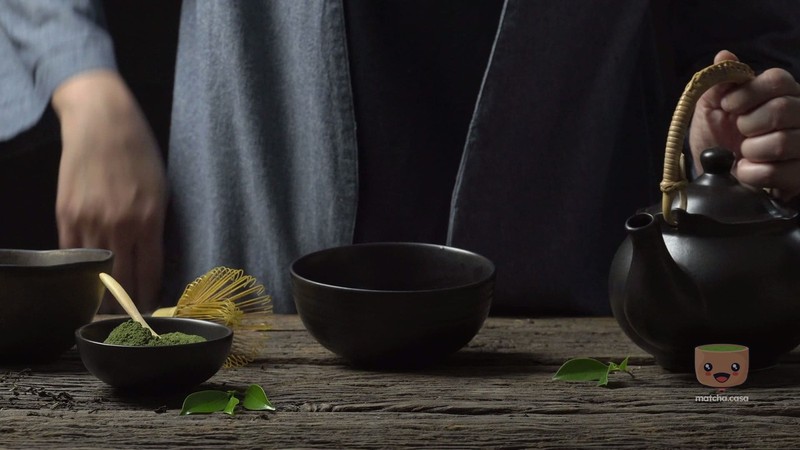 un homme en tenue traditonelle japonaise prépare du thé matcha avec un chassent
